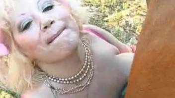 Aroused older woman thrusts massive horse cock into her two moist openings