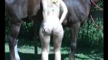 Hardcore fuck scene with a blond-haired babe and a horse